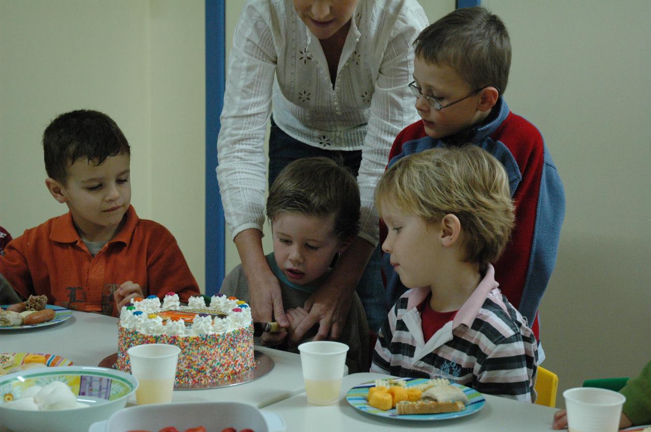 Jake's birthday at Crazy Maze: Michelle cutting the cake, with Jake and Tynan helping as Riley watches