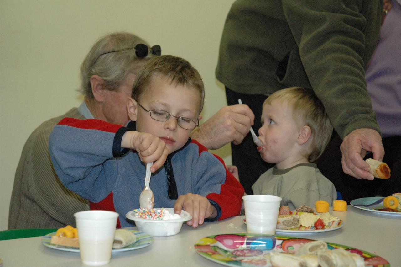 Jake's birthday at Crazy Maze: Peter feeding Flynn the cake with Tynan munching away