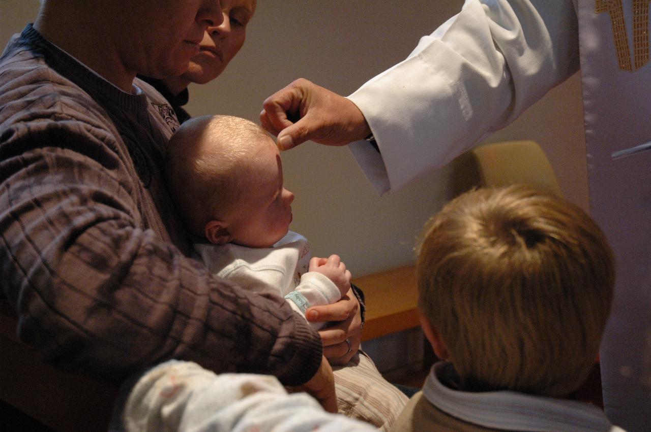 Father Flynn signing Cooper (with the Sign of the Cross) at his Baptism