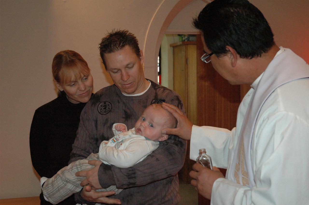 Father Francis annointing Baby Cooper at his Baptism