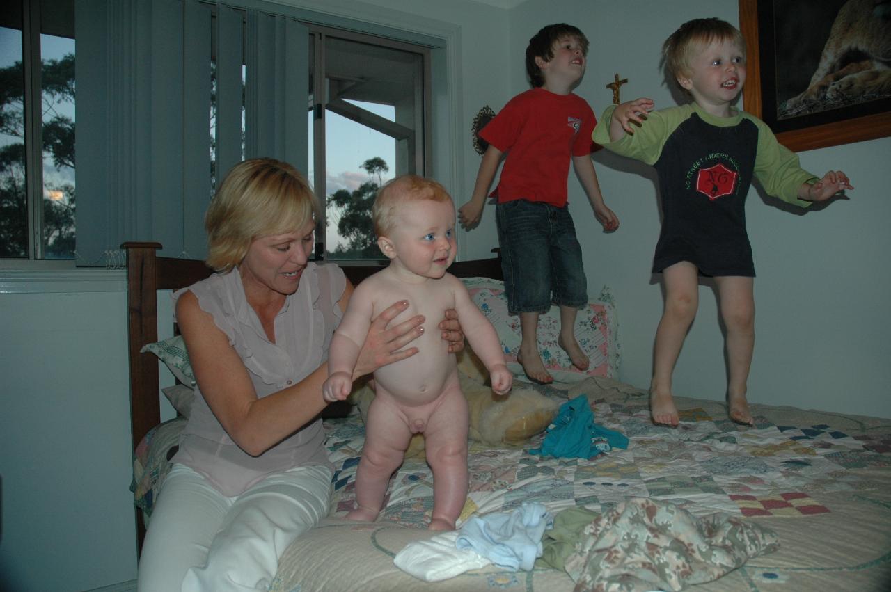 Kelly and boys jumping on the bed