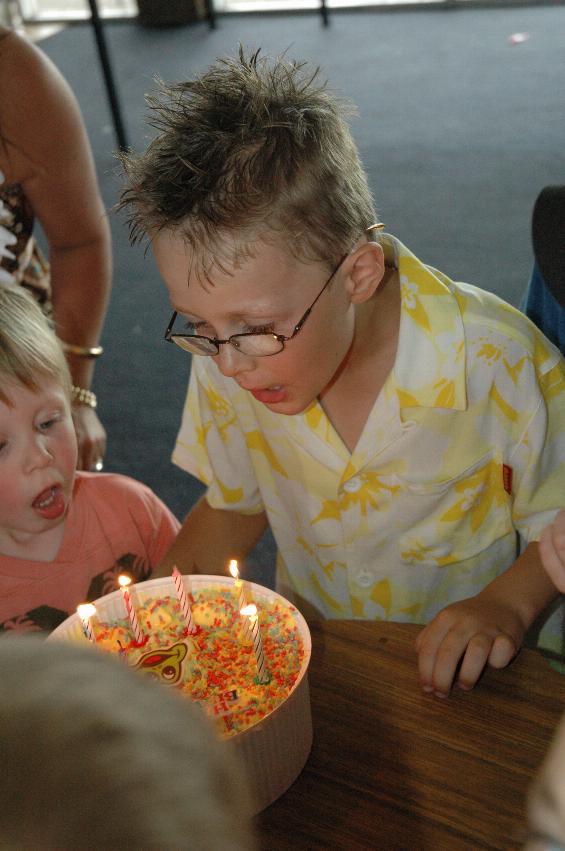 Tynan's 7th birthday party: Tynan blowing out the candles, with some \