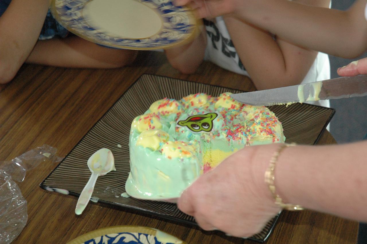 Tynan's 7th birthday party: Yvonne cutting the ice cream cake - now on a dish