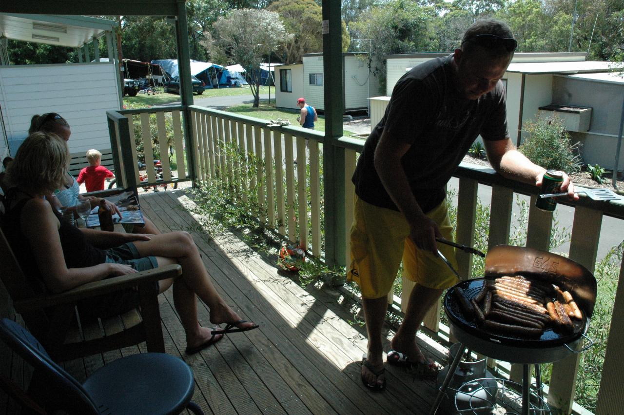 Craig on verandah of Shell's van at Bendalong cooking sausages