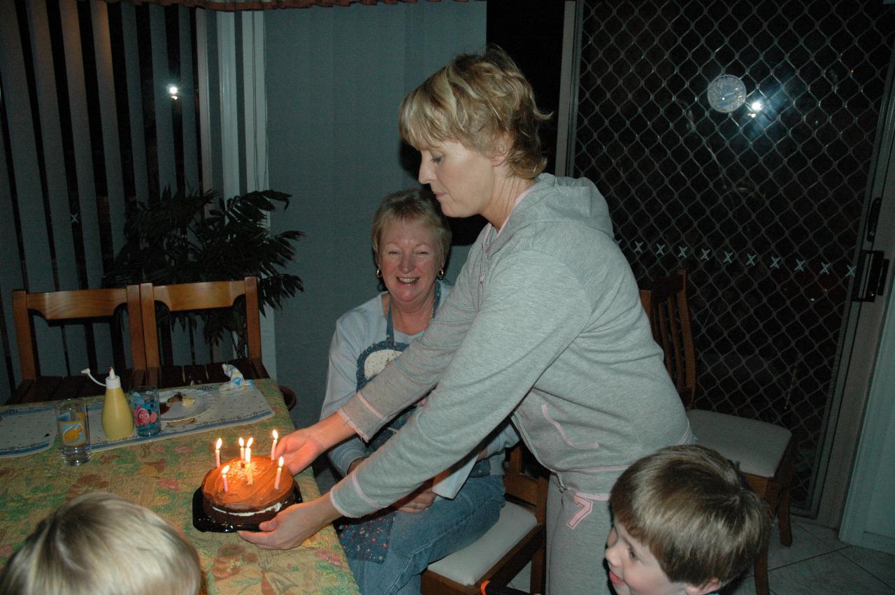 Michelle Crofts bringing in the birthday cake at Yvonne's birthday, with Jake and Flynn (at bottom).