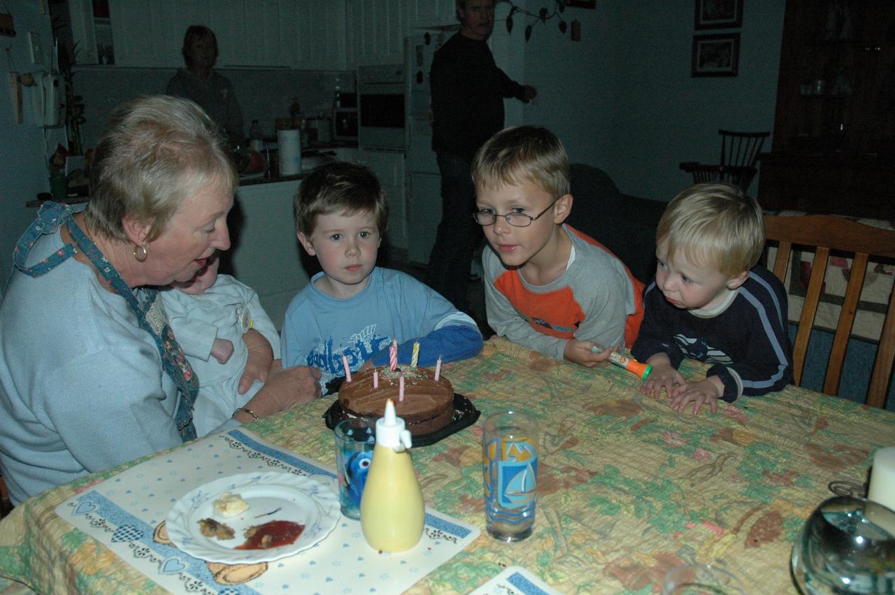 Yvonne blowing out the candles on the cake, with Baby Cooper Wallace and Jake Crofts looking on