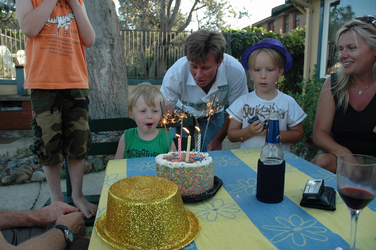 Flynn's third birthday: Flynn starting to blow out candles of cake