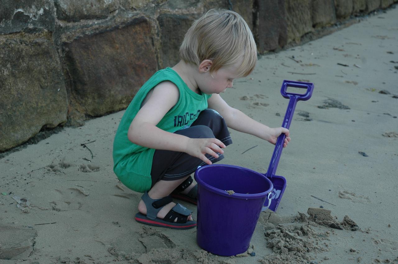 Flynn's third birthday: Flynn with spade and bucket on Croft's beach at Woronora