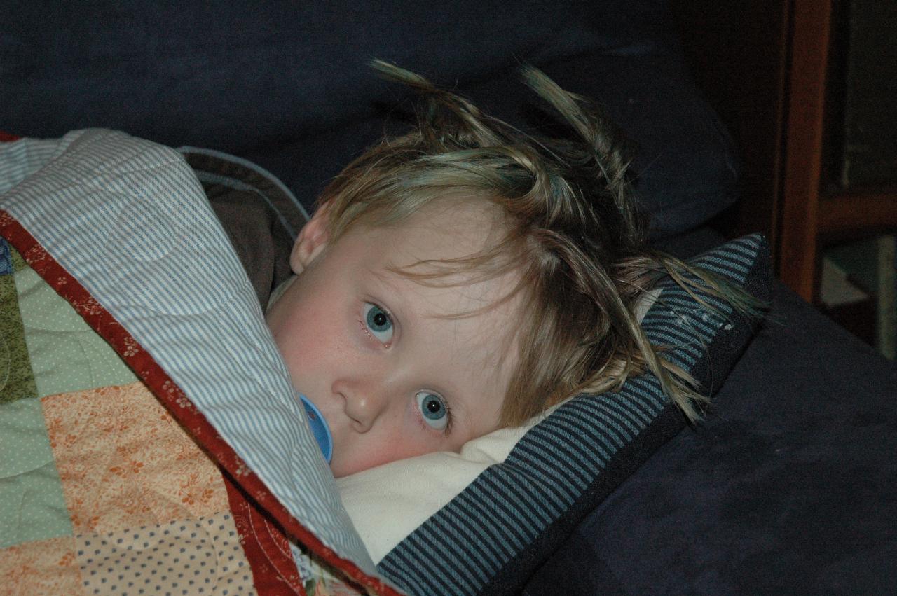 Tired little boy on lounge, spiky hair and all