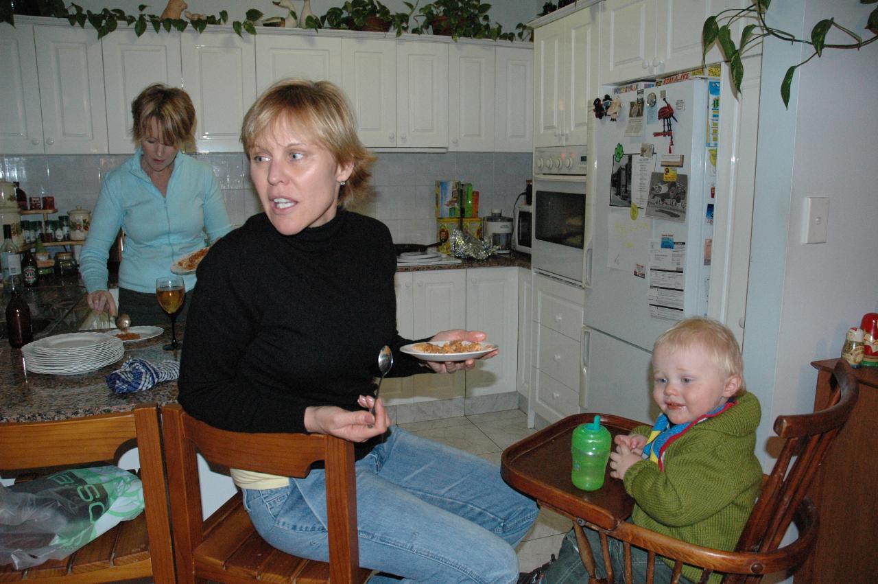 Mother and baby in high chair, both staring to side