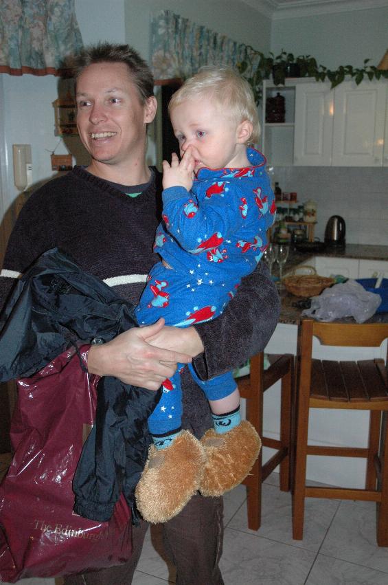 Baby in blue pyjamas in his dady's arms