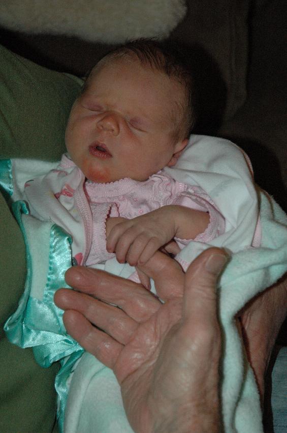 Lily in Yvonne's arms at Kurnell with Peter's hand for scale