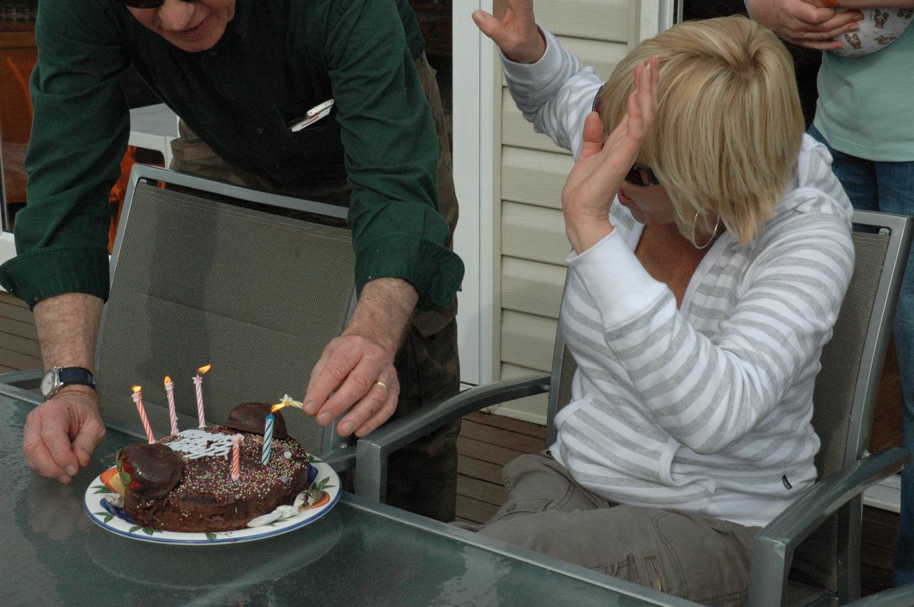 Peter relights some of the candles at the table for Kelly's 39th birthday