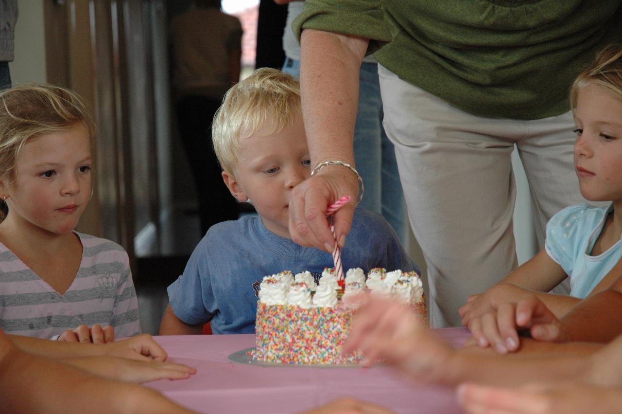 Cooper's 3rd birthday: The cake with candles starting to appear with Yvonne's help