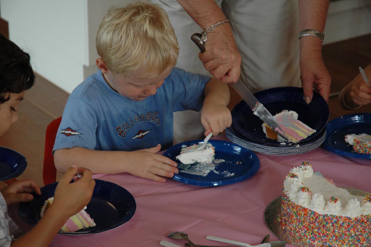 Cooper's 3rd birthday: Cooper eating while Yvonne cuts and serves