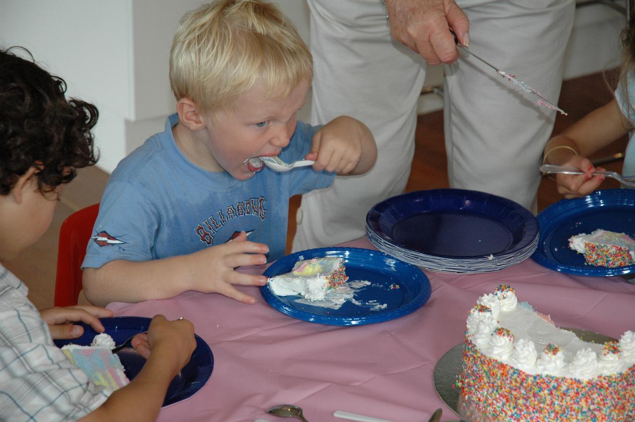 Cooper's 3rd birthday: Cooper eating while Yvonne cuts and serves