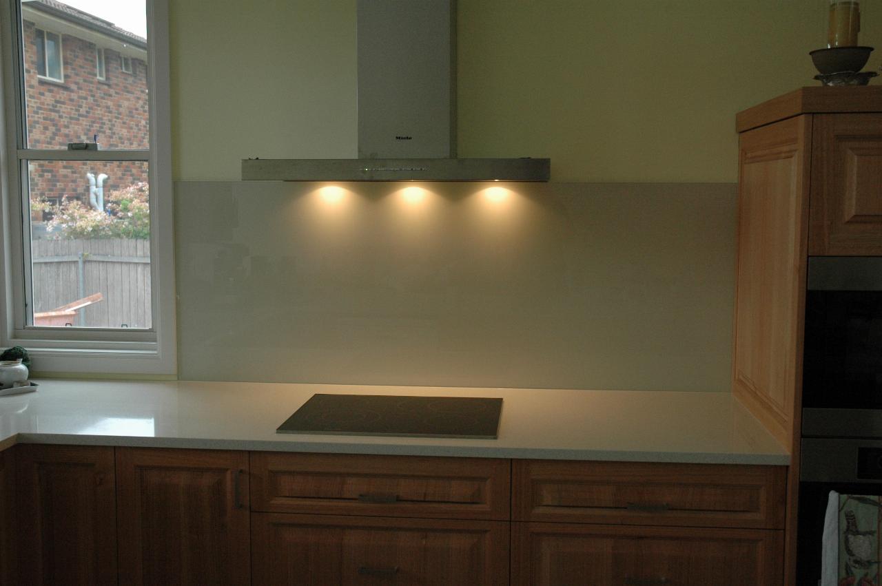 Kitchen showing area around cooktop with range hood lights on