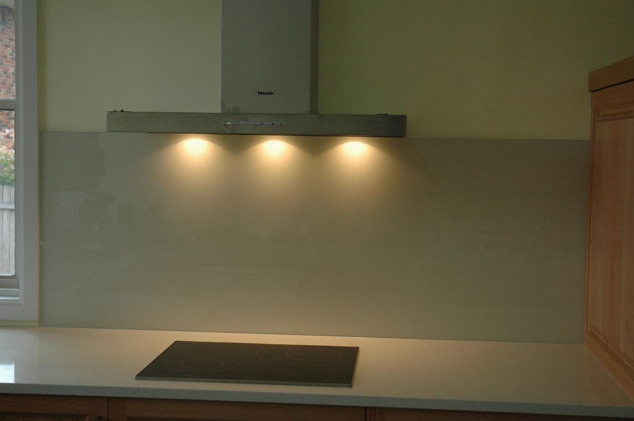 Kitchen showing area around cooktop with range hood lights on