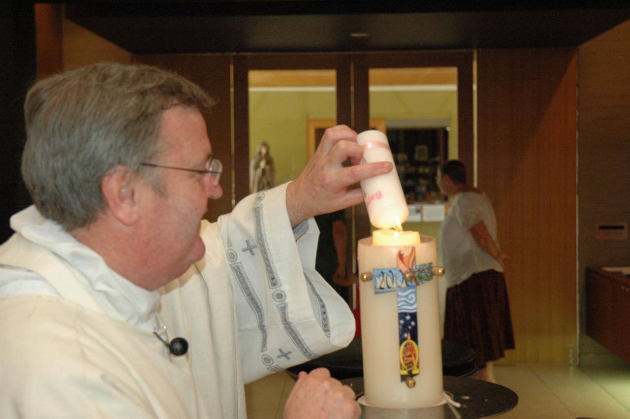 Lily's Baptism: Father Glen lighting Lily's candle