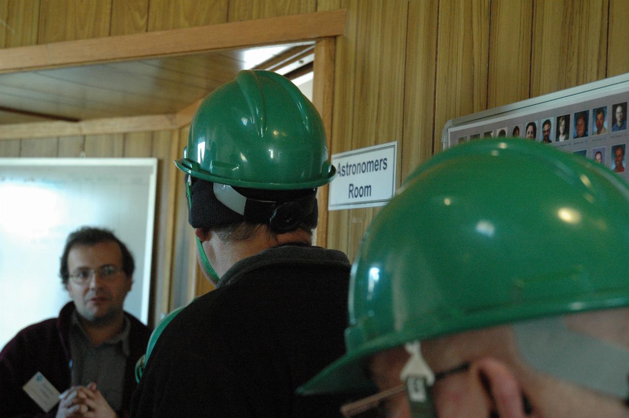 People in hall outside room labelled 