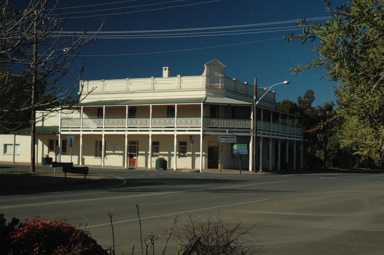 White, two storey building with wooden verandah on upper floor