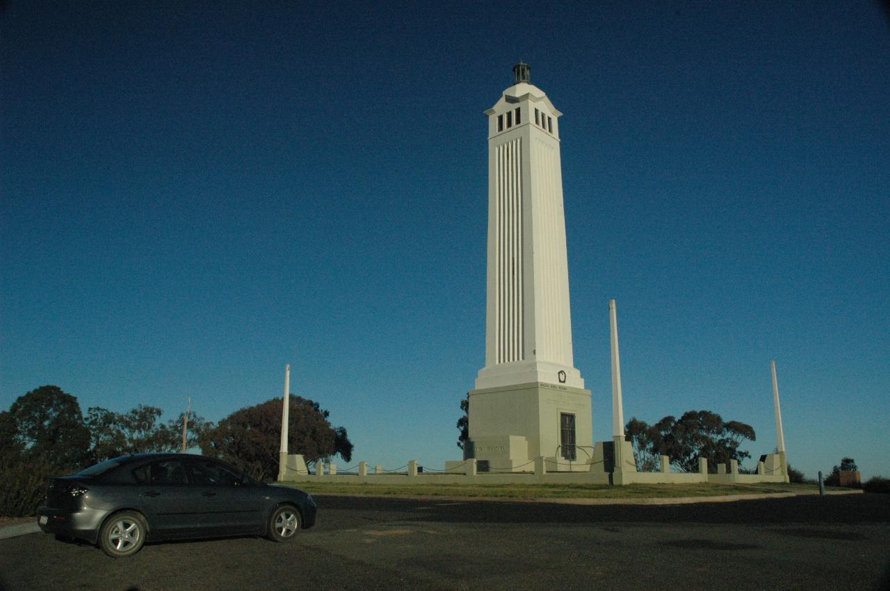 White, 4 story high column on top of hill