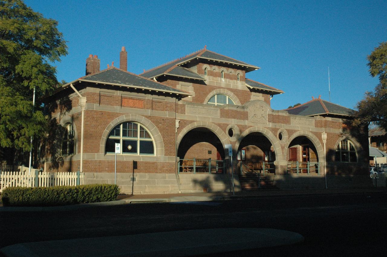 Brick building with semi-circular windows and arches on front