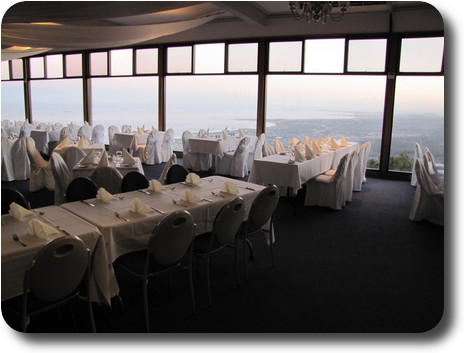 Restaurant with tables against large windows atop cliff