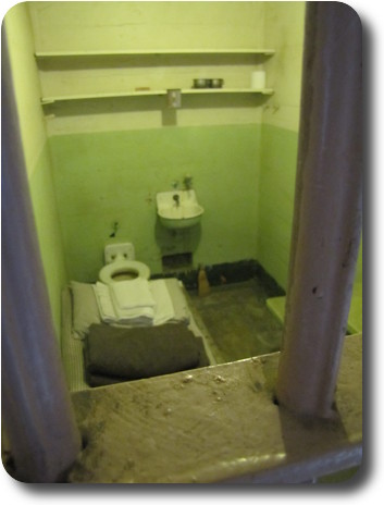 Cell, bed, bed clothes, rules, table, toilet and basin