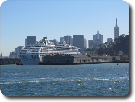 Ocean liner at dock, city skyline behind