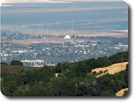 Nearby area looking over flat land adjacent to bay with buildings