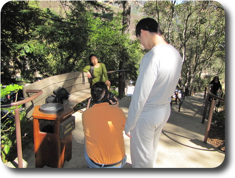 Lady on seat being photographed by two men, one crouched down