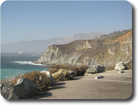 Parking lot at lookout, with rocky coastline disappearing into the distance