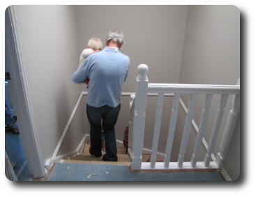 Man carrying baby down stairs