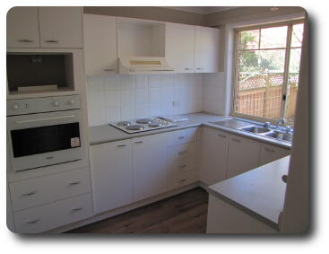 Kitchen; oven to left, sink to right, window above sink