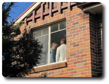 Two women back to upstairs window closeup