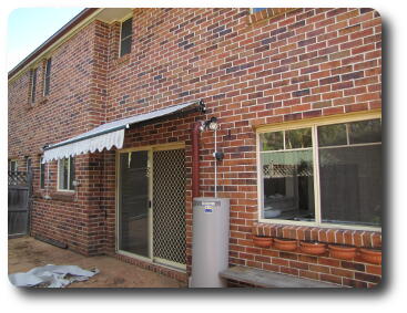 Brick two storey building, with water heater, door and awning