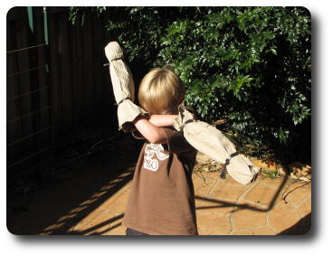 Boy with arms crossed, each inside a cardboard sleeve