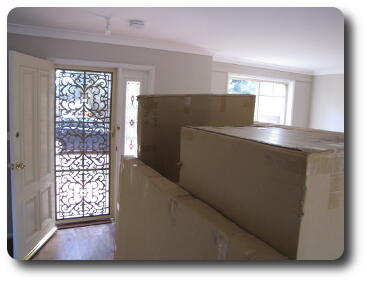 Screen door to left, packing boxes in foreground