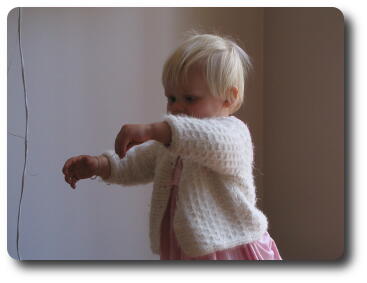 Little girl walking with arms outstretched, carrying something