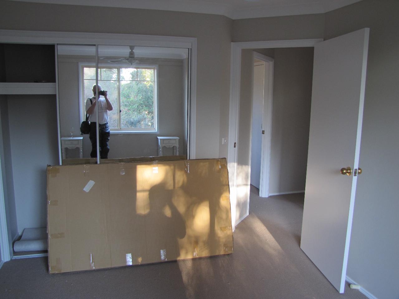 Cardboard package leaning against mirrored wardrobe door