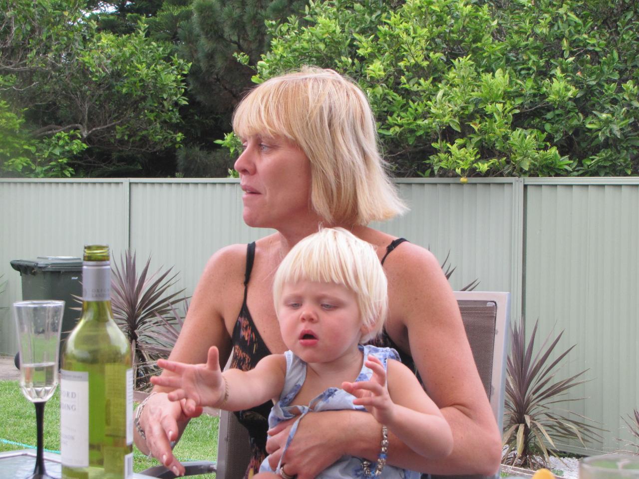 Little girl on mum's lap sees bottle