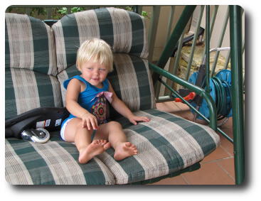 Little girl sitting on swinging seat