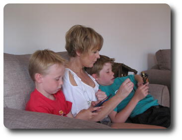 Adult and 2 children playing with electronic games and/or phone