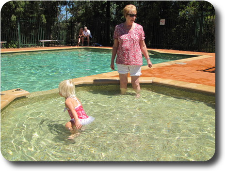 Little girl in wading pool with grandmother