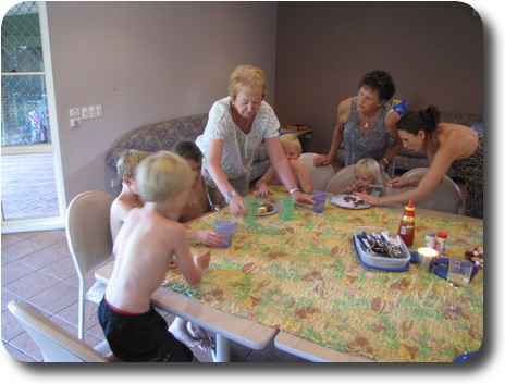 Youngsters sitting around table with a couple of adults