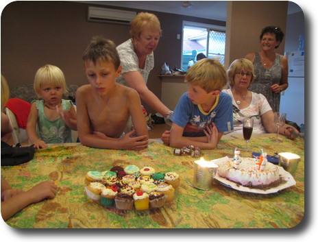 Youngsters and staff around table and cake