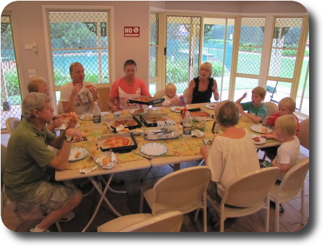 Adults and children sitting around indoor table