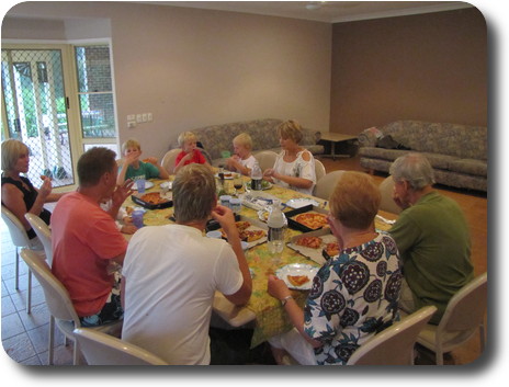 Adults and children sitting around indoor table