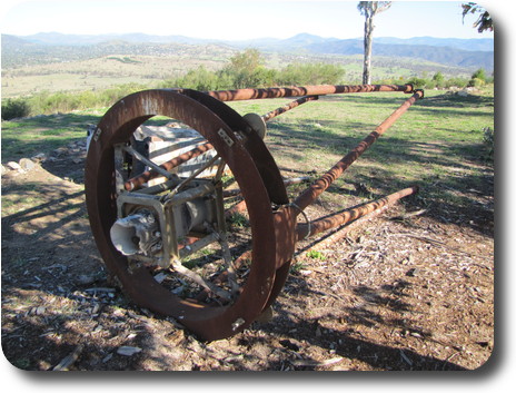 Rusted ring with legs and damaged centre components, on it side in the open